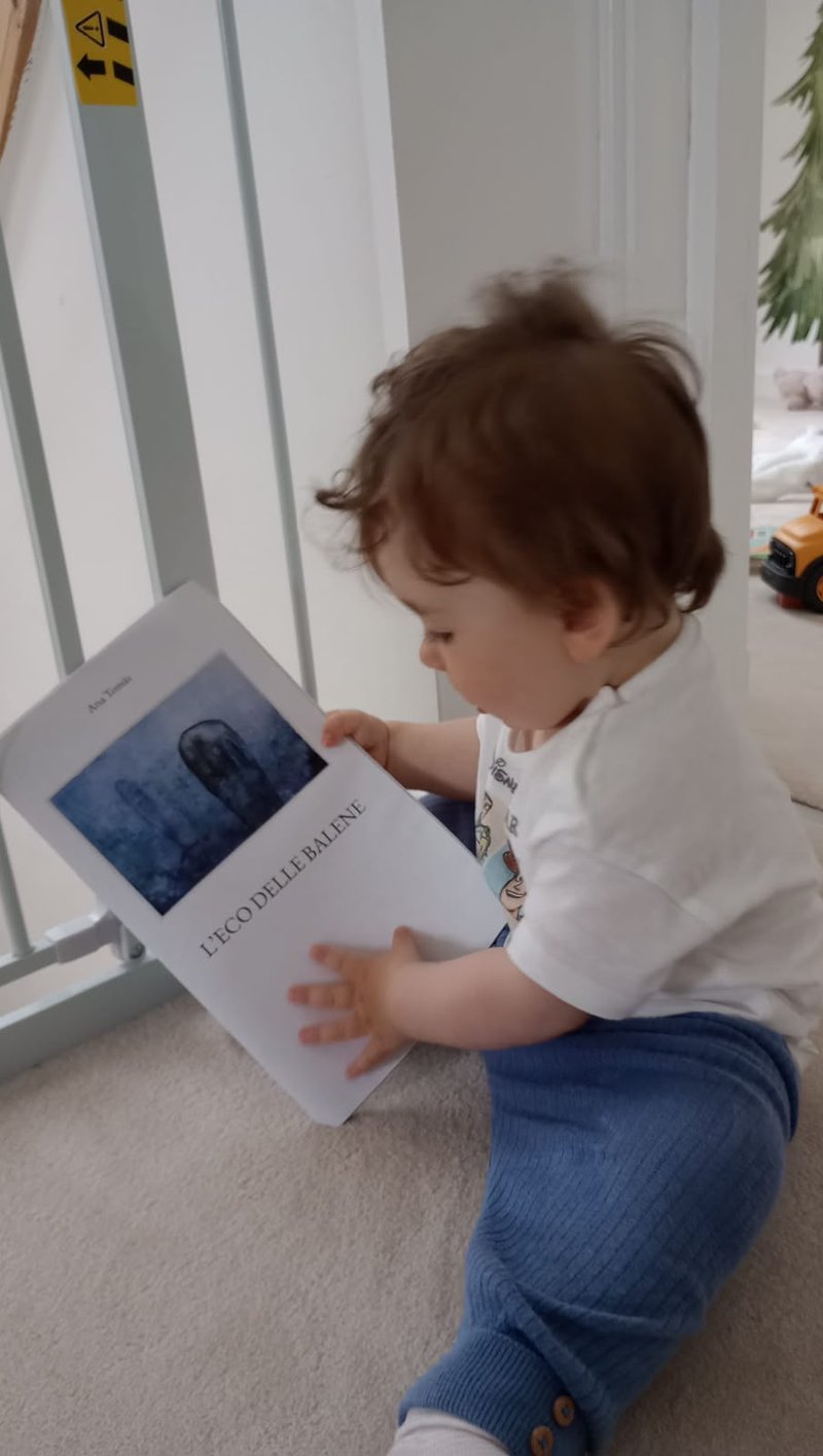 Un bambino che sfoglia il libro L'eco delle balene